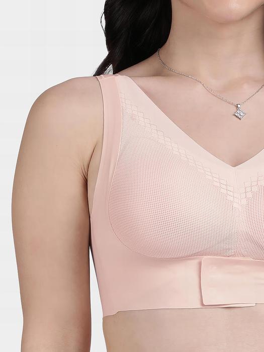 Plumvera model wearing peach front hook seamless bra with V neckline wide straps textured cups