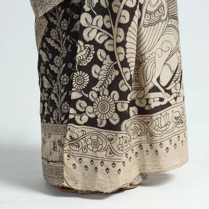 Plumvera black kalamkari cotton saree drape showing beige floral and peacock motifs with decorative border