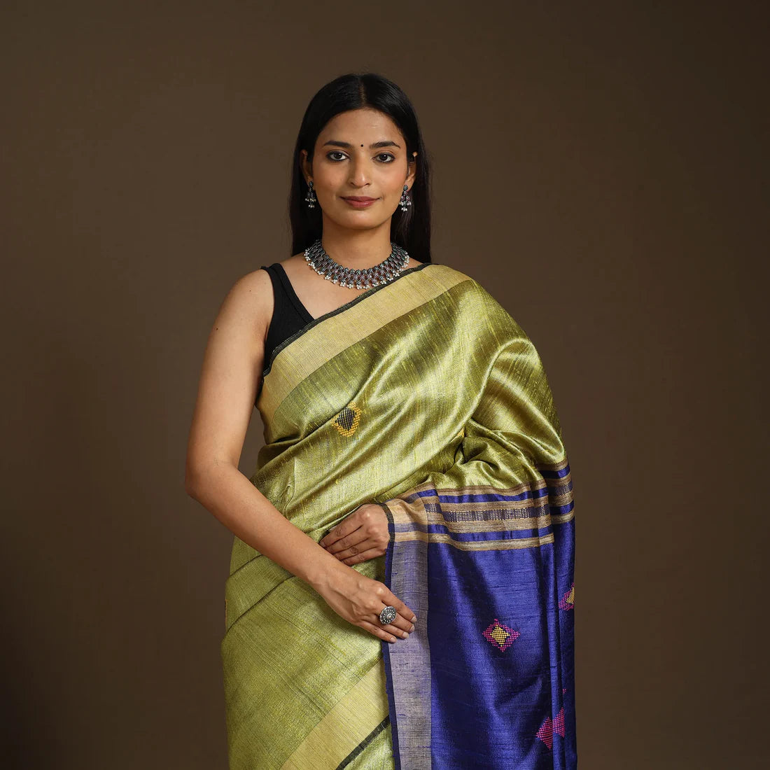 Plumvera model wearing green Tussar silk Bhagalpuri saree with blue contrast pallu and silver necklace