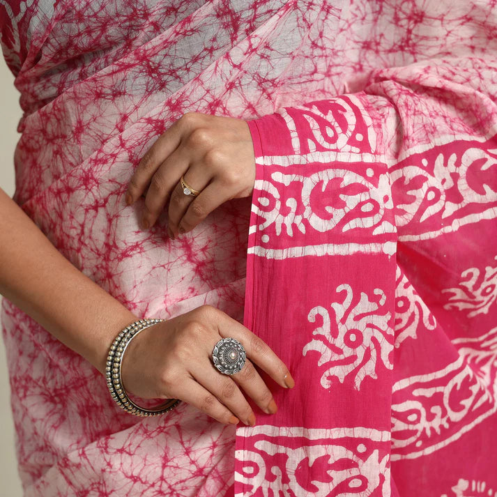 Plumvera pink batik cotton saree draped on model showing tie dye pattern white printed border with silver bangles and ring