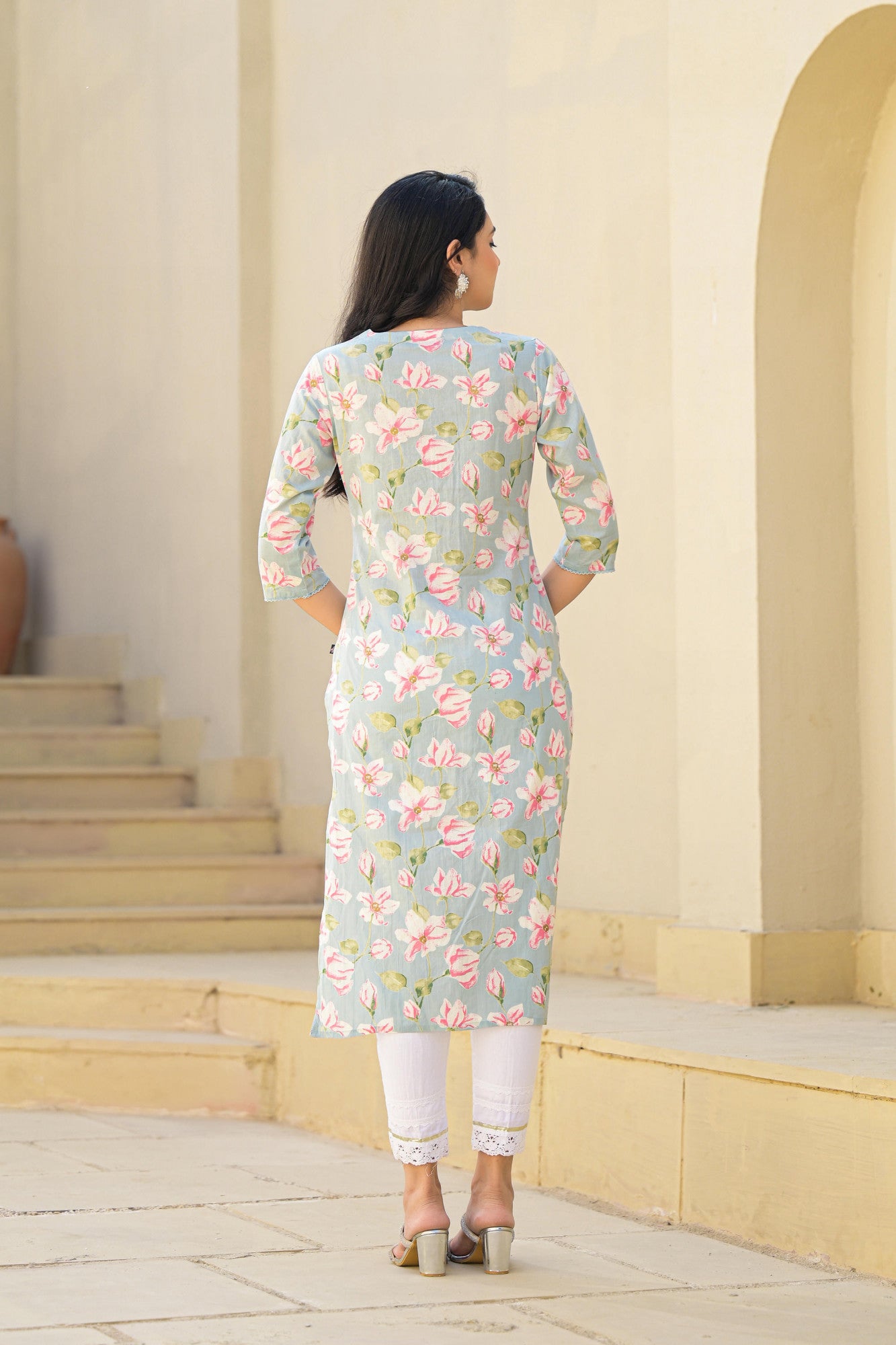 Back view of woman wearing Juniper green floral cotton kurta with three quarter sleeves and white leggings