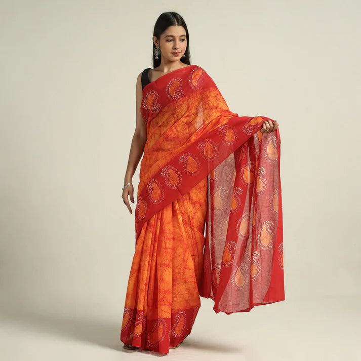 Plumvera orange red hand batik cotton saree with paisley motifs worn with black blouse holding pallu