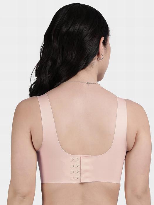 Back view of model wearing peach front hook seamless bra with wide straps and rear hook closure