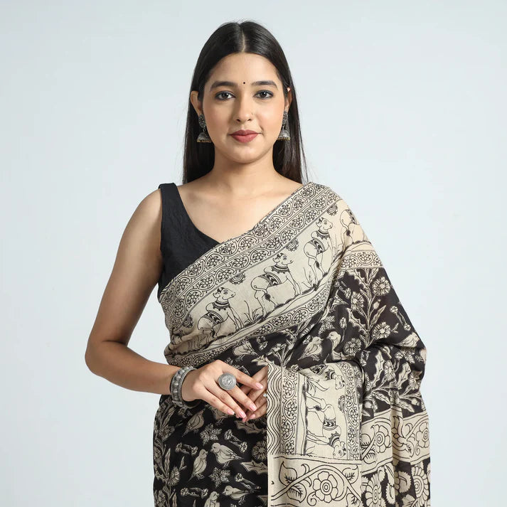 Plumvera model wearing black kalamkari cotton saree with beige floral motifs and traditional border