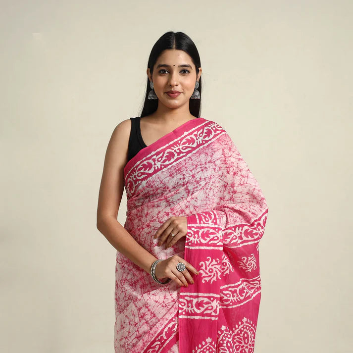Plumvera model wearing pink batik cotton saree draped with floral border pattern and silver earrings