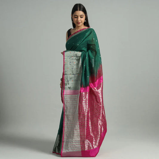 Model wearing a green and pink Venkatagiri silk cotton saree with silver zari pallu and small woven motifs