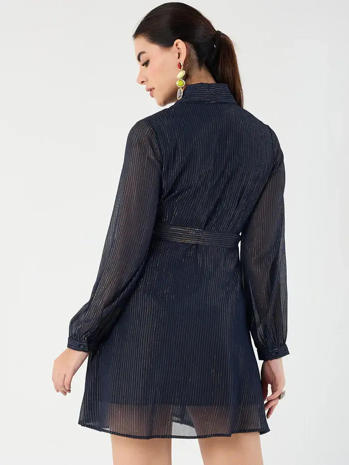 Back view of model wearing Femella navy belted mini dress with long sheer sleeves and pleated fabric
